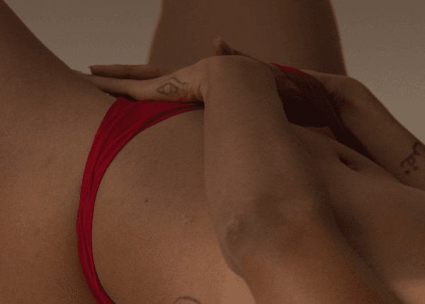 Une main caresse son entre-jambe