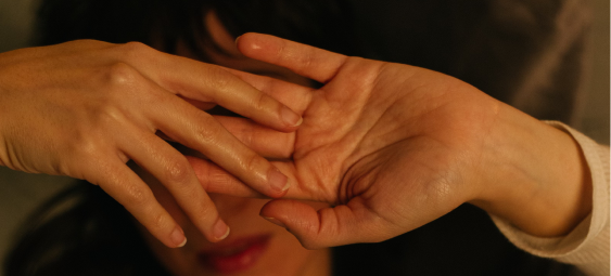 Two hands gently touching, set against a background of subtle, muted tones.