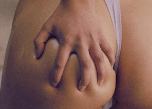 une main pétrit une fesse