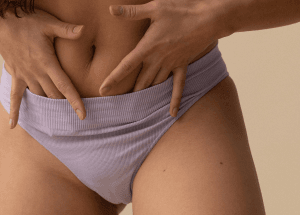 Eine Person führt zwei Hände in ihren lila Slip. 