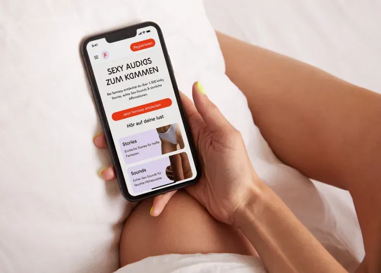 Frau hält Smartphone mit femtasy-Website in der Hand