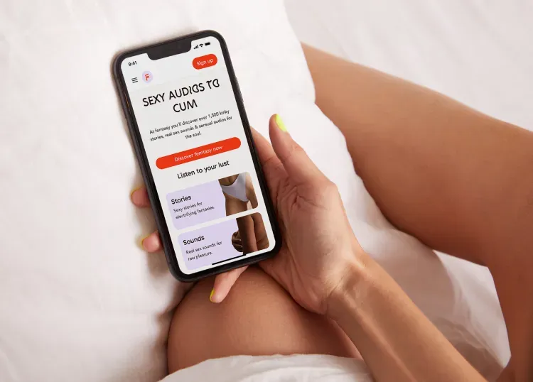 Woman holding smartphone with femtasy website